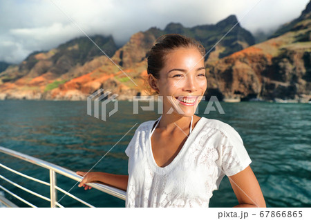Cruise ship boat tourist on Na Pali Coast of Kauai, Hawaii. Sunset cruise ride leisure activity happy Asian tourist in NaPali. Smiling Asian woman on deck having summer holiday 67866865