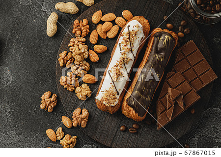 Eclair cake on dark wooden board on black table 67867015