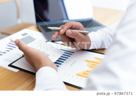 Businessmen use calculators to calculate the cost of real estate investments to prepare for offering to customers who want to share shares with the company, Business Financing Accounting Banking Conce 67867371