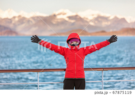Alaska Glacier bay cruise travel fun tourist excited looking at inside passage. Happy woman with open arms in joy of seeing Alaskan nature landscape in the USA 67875119