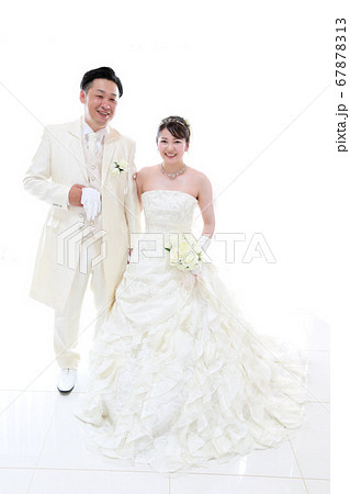 ウエディングドレスとタキシードの新郎新婦フォトウエディング白バック背景の写真素材