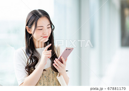 キャンパスでスマホを操作する大学生の写真素材 キャンパスでスマホを操作する大学生の写真素材