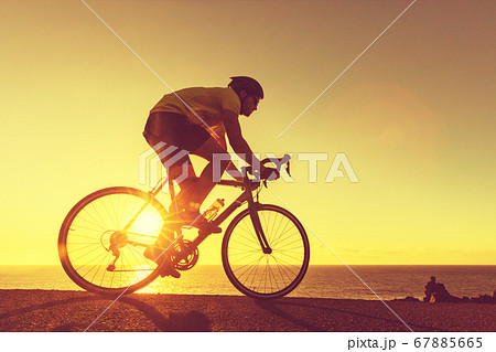 Road bike cyclist man cycling in sunset 67885665