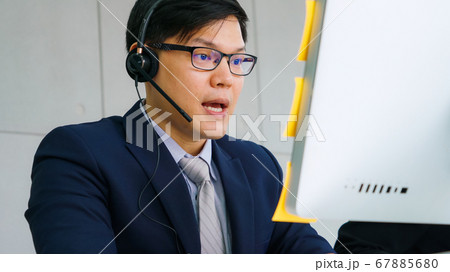 Business people wearing headset working in office Business people wearing headset working in office 67885680