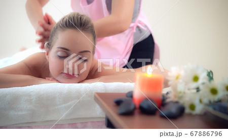 Woman gets back massage spa by massage therapist. Woman gets back massage spa by massage therapist. 67886796