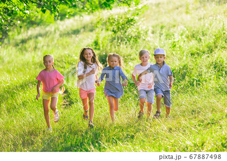 Kids, children running on meadow in summer's sunlight 67887498
