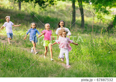 Kids, children running on meadow in summer's sunlight 67887532
