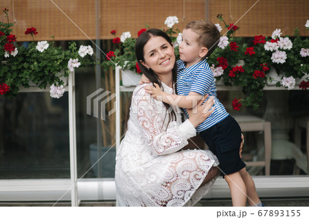 Little sun kiss mom in cheek and hug. Happy family Little sun kiss mom in cheek and hug. Happy family 67893155