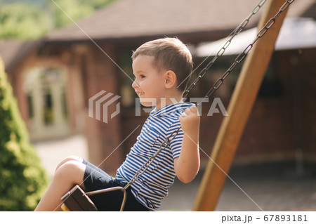 Little boy on the swing. Happy kid outdoors 67893181