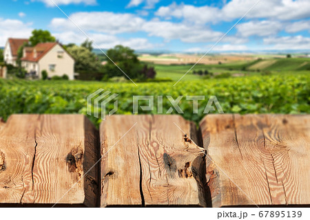Wooden boards or countertop against blurred countryside landscape on background. Use as mockup for display or montage of your products. Close up 67895139