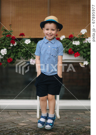 Portrait of little boy outdoor in summer time. Happy smiled kid. in straw hat jump 67895977