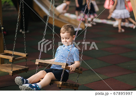 Little boy on the swing. Happy kid outdoors 67895997