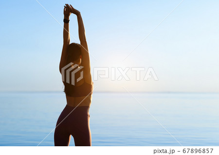 Lady preparing for cardio workout, stretching arms Lady preparing for cardio workout, stretching arms 67896857