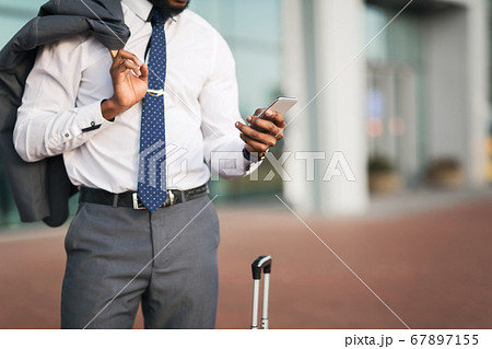 Unrecognizable African Businessman Using Phone At Rail Station, Cropped Unrecognizable African Businessman Using Phone At Rail Station, Cropped 67897155