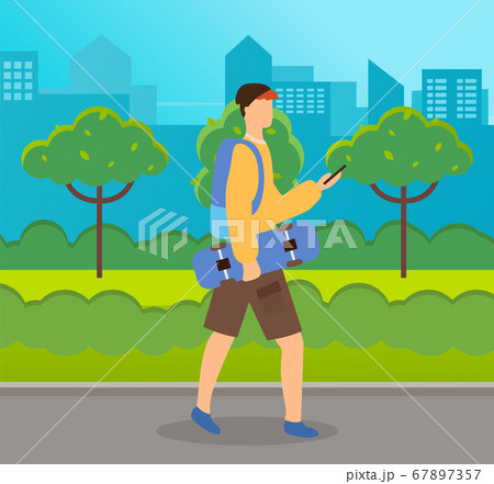 Teenager in city park. Guy holding board on wheels looking at smartphone walking down the street 67897357