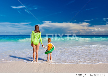 Toddler boy on beach with mother 67898585