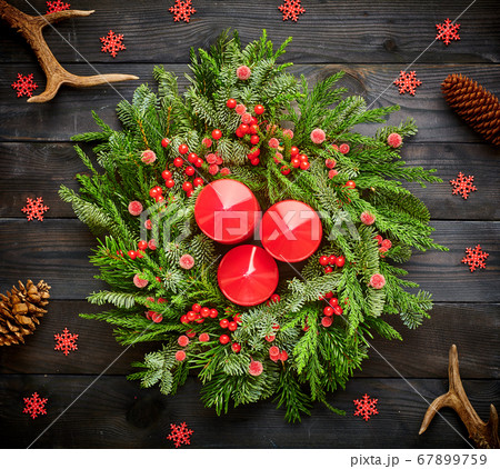 Christmas wreath and candles on wooden background Christmas wreath and candles on wooden background 67899759