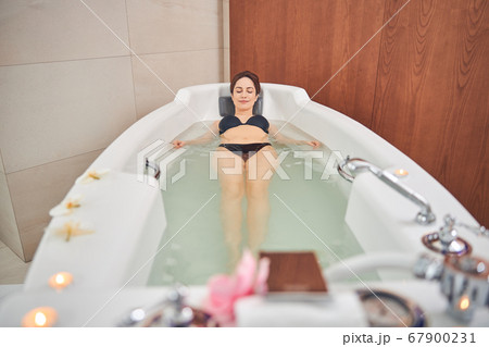 Pleasant brunette female in swimming suit resting Pleasant brunette female in swimming suit resting 67900231