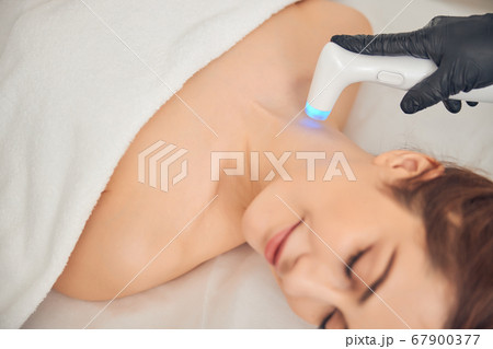 Beautician caring about skin on neck of client Beautician caring about skin on neck of client 67900377
