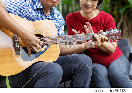 Middle aged couple playing guitar while relax Middle aged couple playing guitar while relax 67901899