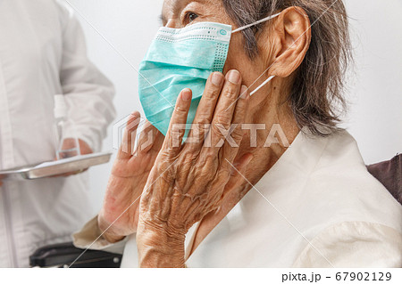 Elderly woman wearing a mask to protect from Elderly woman wearing a mask to protect from 67902129