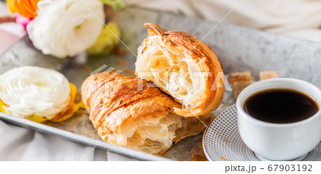 Fresh Croissant, Cup of Coffee and Ranunculus Flowers. Breakfast Fresh Croissant, Cup of Coffee and Ranunculus Flowers. Breakfast 67903192