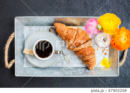 Fresh Croissant, Cup of Coffee and Ranunculus Flowers. Breakfast 67903206