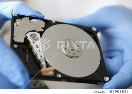 Gloved master holds hard drive away from computer. Gloved master holds hard drive away from computer. 67903852