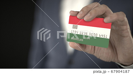 Businessman takes credit card with printed flag of Hungary, fictional numbers 67904187
