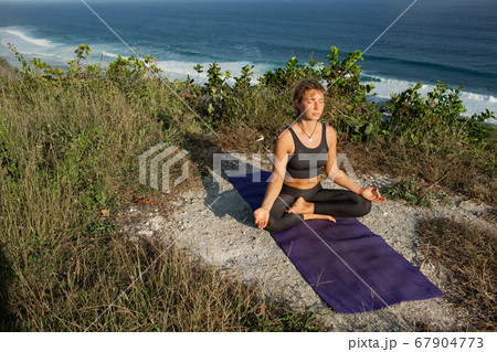 Young woman practicing yoga outdoors Young woman practicing yoga outdoors 67904773