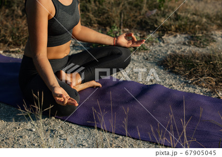 Young woman practicing yoga outdoors Young woman practicing yoga outdoors 67905045
