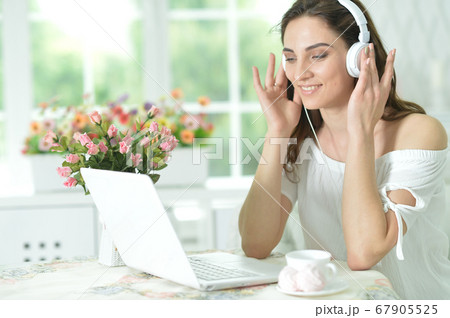 Young woman with laptop listening to music Young woman with laptop listening to music 67905525