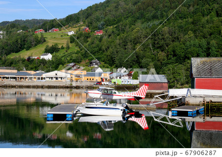 ノルウェー　ハダンゲルフィヨルド、鏡の水面に機影を映す水上艇機セスナU206F ステーションエア6 67906287