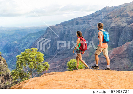 Hikers couple hiking in mountains canyon landscape Hikers couple hiking in mountains canyon landscape 67908724