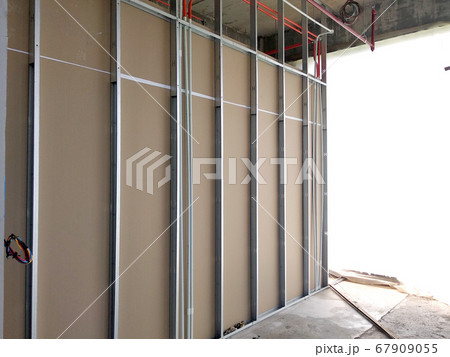 KUALA LUMPUR, MALAYSIA -APRIL 12, 2018: Drywall installation work in progress by construction workers at the construction site. It is the easiest and cheapest way to do partition for the interior wall KUALA LUMPUR, MALAYSIA -APRIL 12, 2018: Drywall installation work in progress by construction workers at the construction site. It is the easiest and cheapest way to do partition for the interior wall 67909055