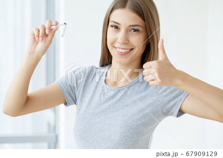 Stop smoking, woman holding a broken cigarette in her hand Stop smoking, woman holding a broken cigarette in her hand 67909129
