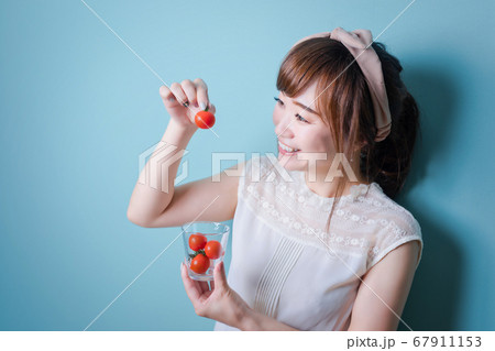 トマトを食べる女性 67911153