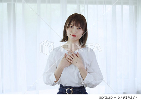 若い女性（胸に手を当てる） 67914377