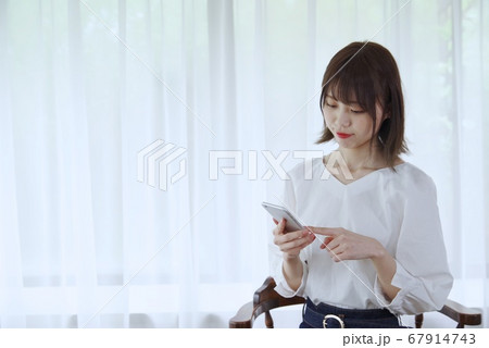 若い女性（スマホを見る） 67914743