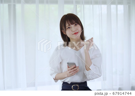 若い女性（スマホを持ちガッポーズする） 67914744