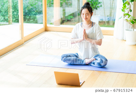 自宅でオンラインヨガをする若い女性 67915324