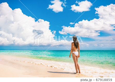 Beach travel luxury vacation bikini woman relaxing on summer holidays with sky landscape background Beach travel luxury vacation bikini woman relaxing on summer holidays with sky landscape background 67918859