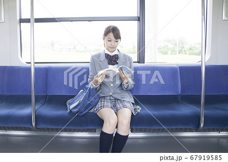電車の中で勉強する女子高校生 67919585