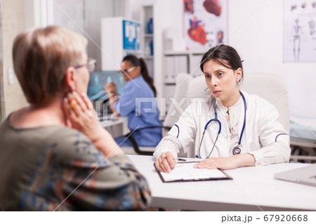 Young doctor examining senior patient 67920668