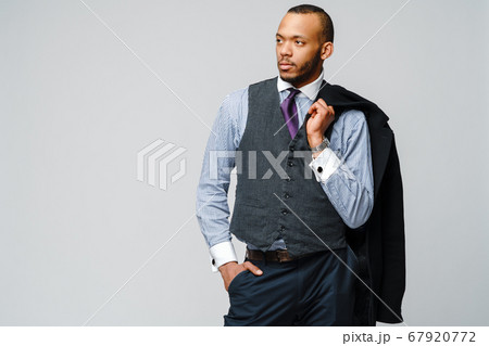 studio shot of a african-american businessman wearing coat over light grey background 67920772