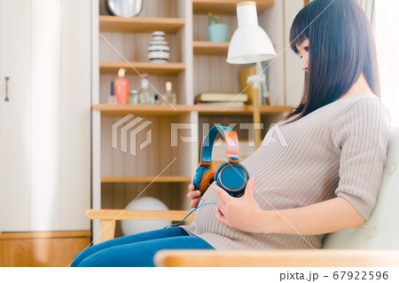 ヘッドフォンをお腹に当てる妊婦 胎教 ヘッドフォンをお腹に当てる妊婦 胎教 67922596