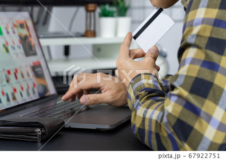 Asian man holding credit card and typing Asian man holding credit card and typing 67922751