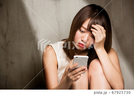 スマートフォン・憂うつな女性 スマートフォン・憂うつな女性 67925730