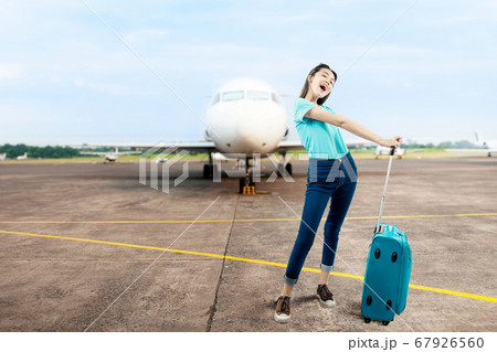 Asian woman standing with a suitcase 67926560
