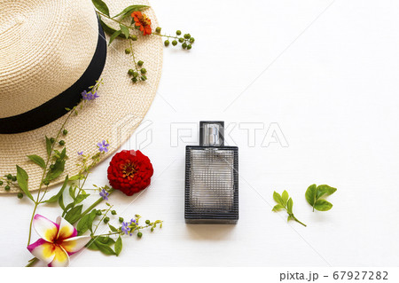 perfume and hat of lifestyle woman relax summer with purple flowers ,zinnia ,frangipani arrangement flat lay style 67927282
